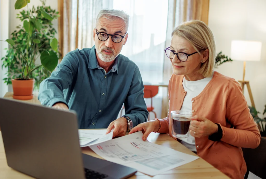 older couple looking at retirement and financial information at the kitchen table