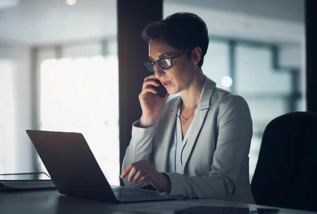 professional in office looking at computer and on the phone