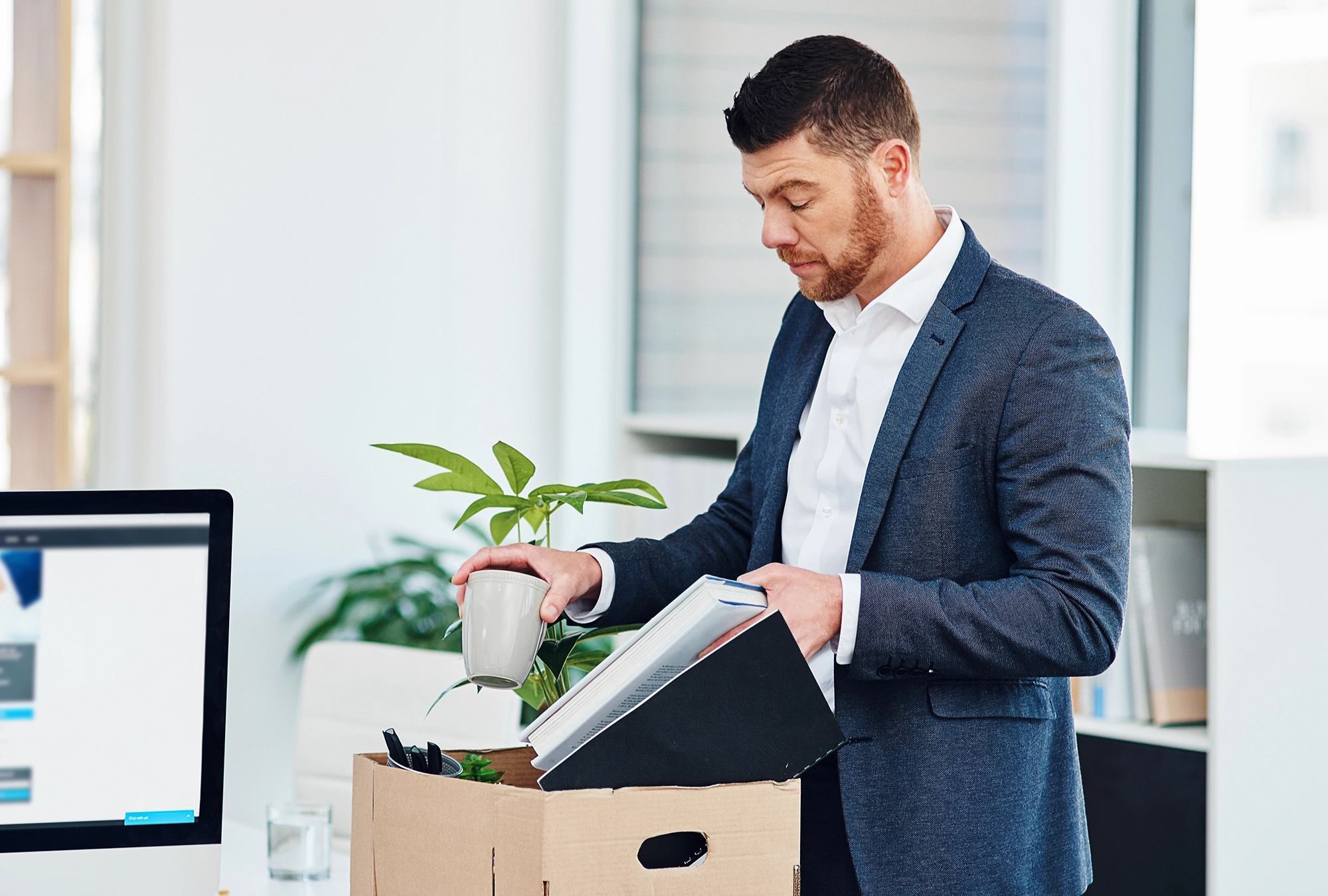 business professional packing his things in office after getting laid off