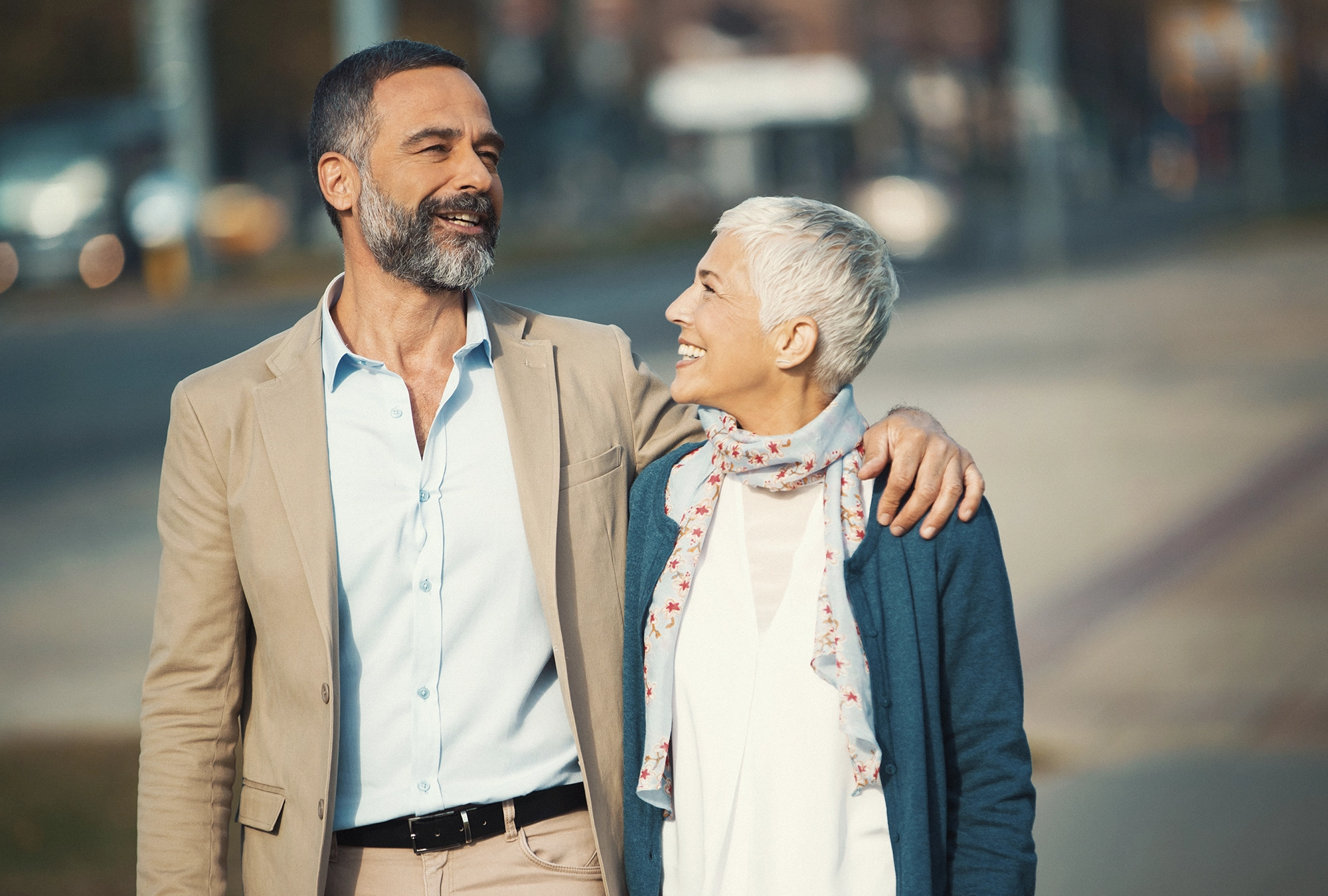 couple walking down the street together, smiling looking at each other