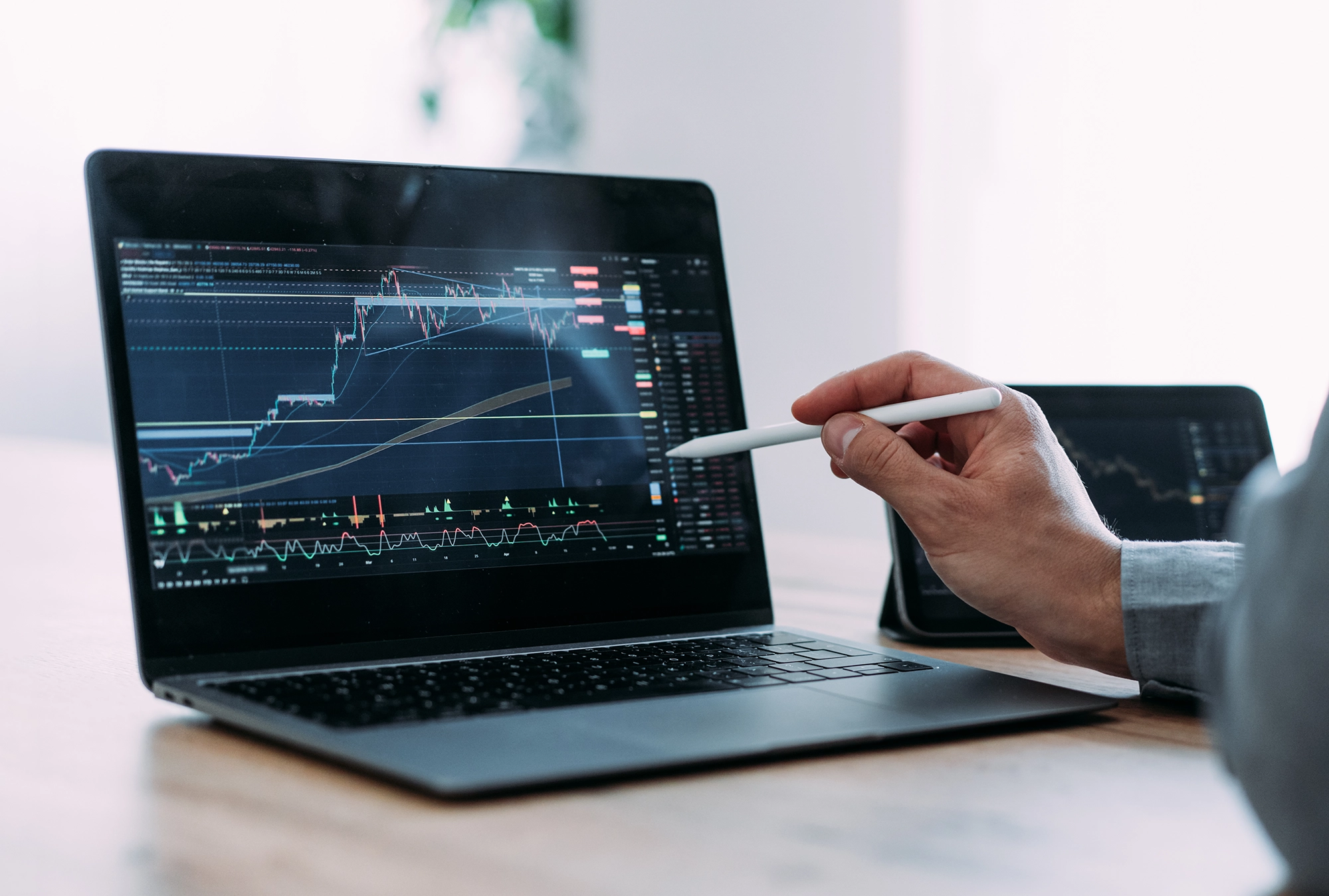 advisor using stylus to point at computer screen showing stocks