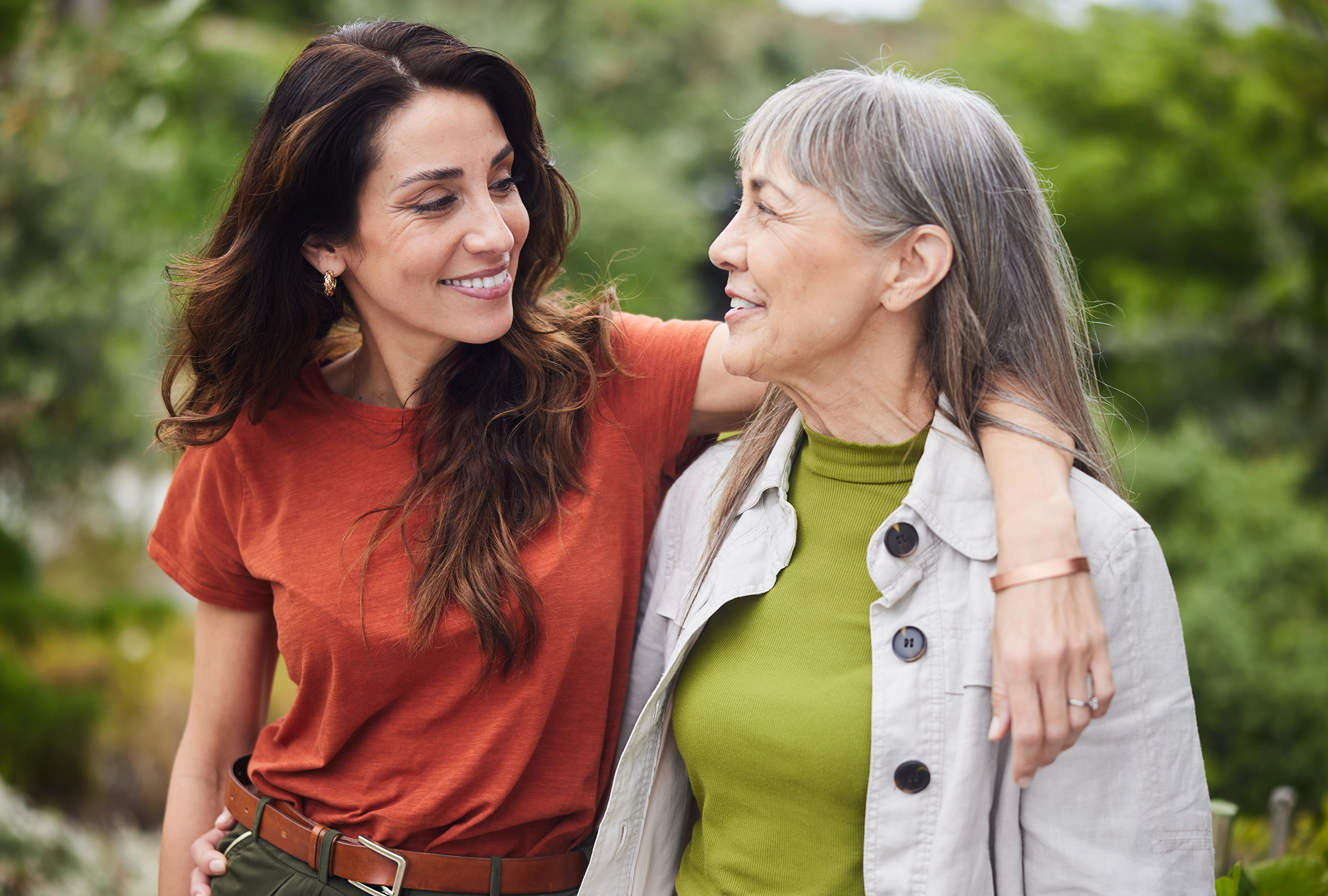 mother and daughter walking and smiling at each other
