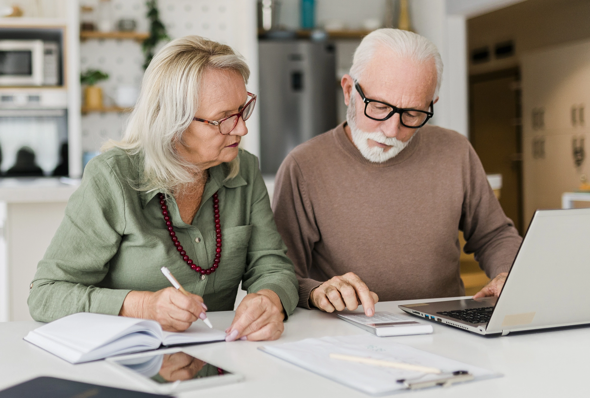 husband and wife calculating taxes at a table